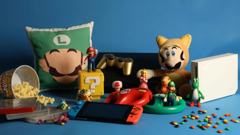 A vibrant assortment of gaming collectibles, including Nintendo figures, consoles, and candy on a blue background.